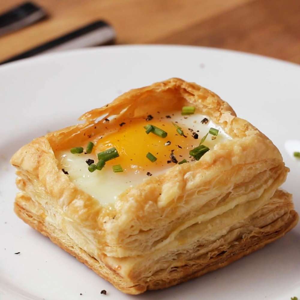 Baked eggs nestled in golden puff pastry squares